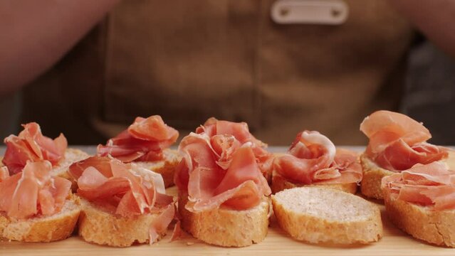 Jamon iberico tapas close up, chef cooking the best spanish ham pork tapas, cafe with traditional food.