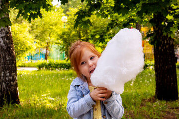 girl eats candy floss in the park