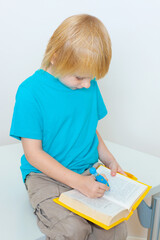 little boy with a book on a light background
