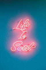 pink neon sign "life is sweet"