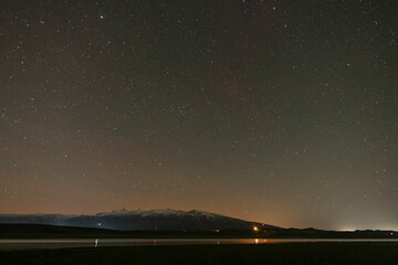 Beautiful night landscape. Starry sky galaxy over the lake .