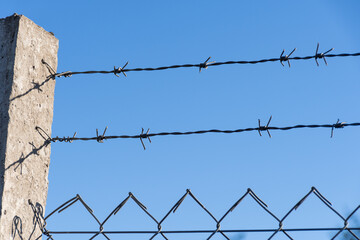 Barbed wire fence connected to a column.