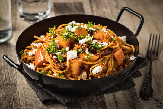 Spaghetti pasta with pumpkin, dried tomatoes and feta cheese