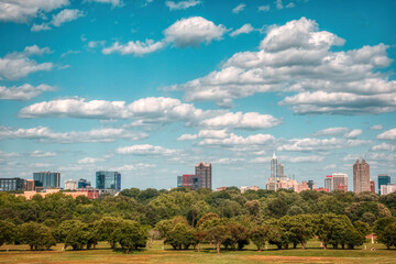 Fototapeta na wymiar A wide-angle Raleigh, North Carolina skyline with puffy clouds in a light blue sky.