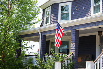 US flag proudly displayed in front of an American house symbolizes patriotism, national identity,...
