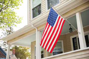 US flag proudly displayed in front of an American house symbolizes patriotism, national identity,...