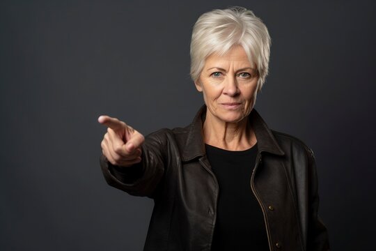 Commanding attention with a pointed finger, a mature woman exudes confidence and authority. Ai Generated.