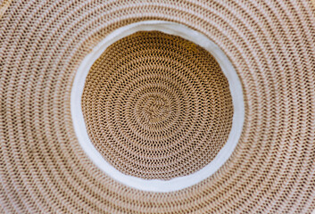 Background, texture of a straw summer hat with a pattern. Photography, top view, accessories.
