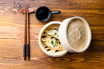 Chinese snacks. chinese steamed dumpling. Chinese Traditional cuisine concept. in wooden steamer soy sauce and chopsticks top view space for text