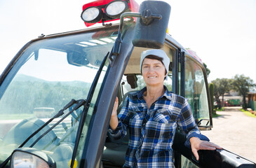 Naklejka premium Portrait of female farmer in the special car at the cow farm.