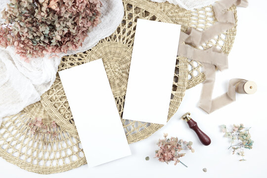 Double sided 4x9 menu card. Wedding stationery suite mock-up styled with boho decor, dried hydrangea flowers bouquet, rattan lace mats, vintage wax seal, and silk ribbon.