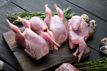 Fresh  raw meat quails ready for cooking, on black wooden background