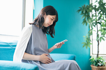 スマートフォンを見る妊婦