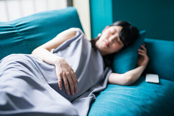 ソファで昼寝をする妊婦