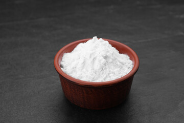 Bowl of natural starch on black table, closeup