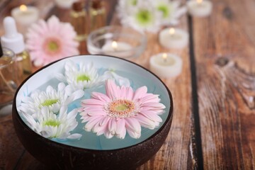 Fototapeta na wymiar Spa composition. Bowl with water and beautiful flowers on wooden table, closeup. Space for text
