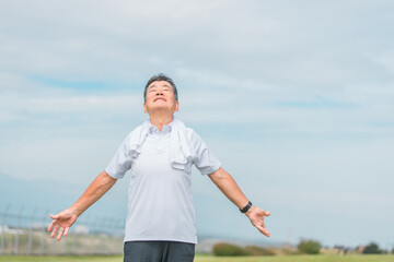 公園でラジオ体操・ストレッチ・深呼吸・柔軟体操をする高齢者男性
