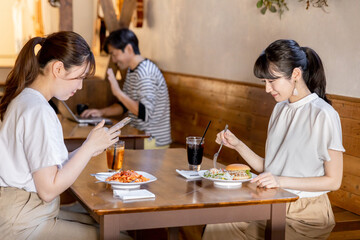 Fototapeta na wymiar カフェ・社員食堂でランチをとるアジア人女性たち 