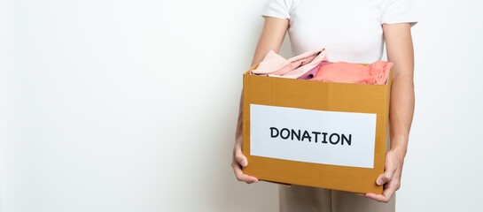 Donation, Charity, Volunteer, Giving and Delivery Concept. People donate Clothes into Donation box at home or office for support and help poor, refugee and homeless people. Copy space for text