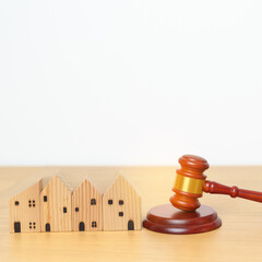 Real Estate Law, Home Insurance, property Tax, Auction and Bidding concepts. small toy house model with gavel justice hammer on desk in courthouse.