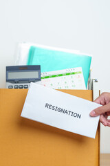 Resignation, Layoff, Unemployment, Dismiss, Job quit, Jobless and Farewell concept. Businessman holding letter of Resign contract with documents cardboard box at office