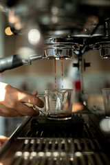 Barista pouring coffee into a cup, closeup. Professional coffee brewing