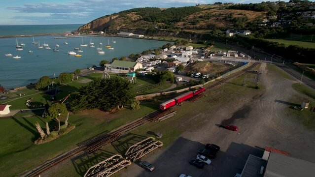 Aerial view of red train passing on beautiful scenic coastal railway. Oamaru, New Zealand