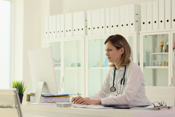 Worker in field of medicine enters patient data on computer