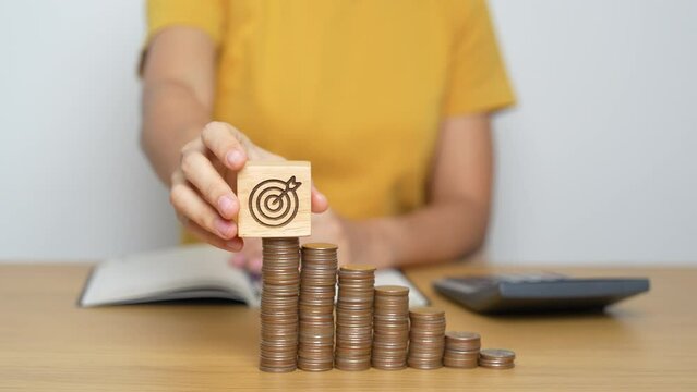 Money Saving for Future Plan, Retirement fund, budget, Goal and strategy Investment, Wealth Business and Financial concepts. Woman with Coins stack and dartboard block on table