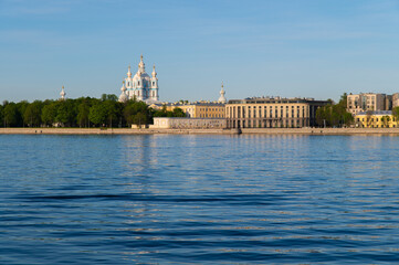 Fototapeta premium Saint-Petersburg, Russia. May 20, 2020: Granite city embankment with a park and a cathedral illuminated by the morning sun
