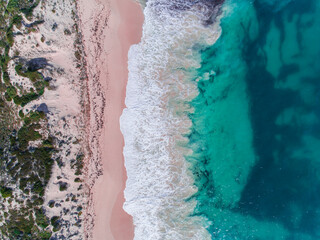 Fototapeta na wymiar Aerial view of sandy beach with waves on beach. Sunny day in summer with transparent tropical blue water. Western Australia, Australia. Top view. Coastal, Seascape