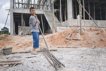 Children violence and abused concept. Little boy labor working in commercial building structure, World Day Against Child Labour concept.