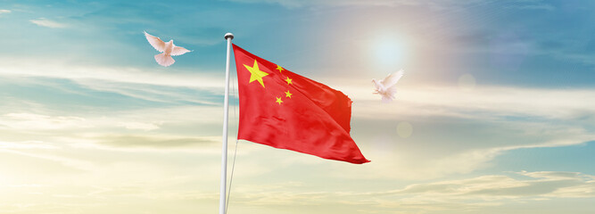 Waving Flag of China in Blue Sky. The symbol of the state on wavy cotton fabric.