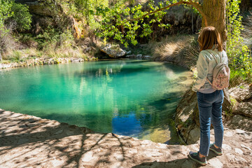 Woman hiker contemplating the beautiful and quiet lagoon called Aguallueve in Anento, Zaragoza.