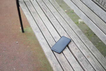 Fototapeta na wymiar forget smartphone on a park bench, lost smart phone 