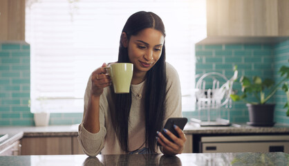 Reading, phone and woman with coffee in a kitchen relax with social media, app or texting. Smartphone, streaming and female drinking tea in her home on day off, calm and peaceful in her apartment