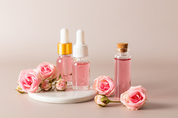 Obraz na płótnie Canvas A set of cosmetics in various bottles based on the extract of rose petals on pastel background. facial skin care. natural cosmetics.