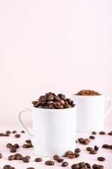 Fototapeta na wymiar Roasted coffee beans and instant coffee in cups on pink background vertical view