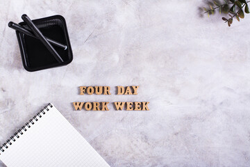 Four day work week concept with wooden letters on desk top view