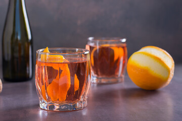 Low alcohol cocktail Negroni Sbagliato with sparkling wine and orange in glasses on the table