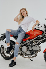 Fototapeta na wymiar Studio shot of isolated in white background blond woman and custom modern motorcycle.