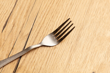 Fork on the wooden table, closeup shot, shallow depth of field