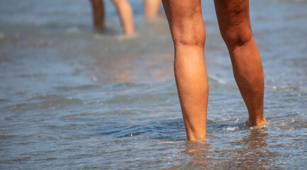 Feet of a woman on a pebbly seashore