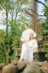 Happy couple posing outdoor among trees and rocks