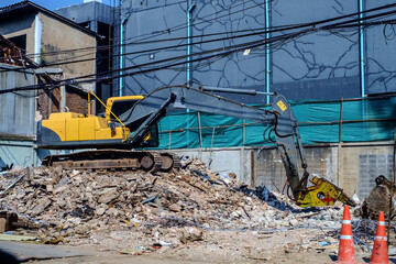 Excavator destroying old concrete building