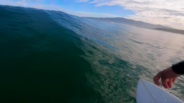 An athlete on a wave board rides the perfect ocean waves of a living beach break in the Atlantic Ocean. One of the best surf spots on the planet. Sports hobby.