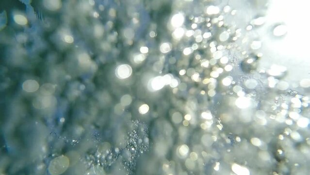 slow motion of water closing on camera while camera is forced underwater, beautiful bubbles everywhere. refreshing effect