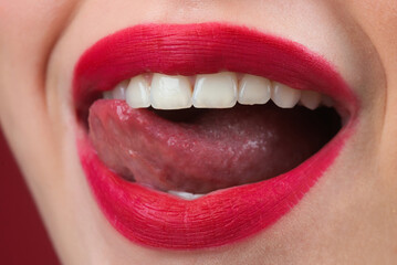 Girl puts lipstick on lips with a brush. Close-up of womens lips with lipstick. Applying lipstick on a lip. Professional lipstick.