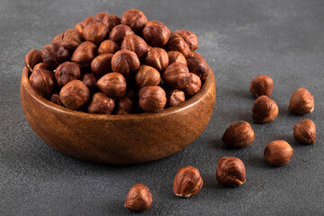 View of a bowl full of hazelnuts on a black background
