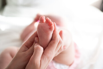 Little baby feet in mother's hands 